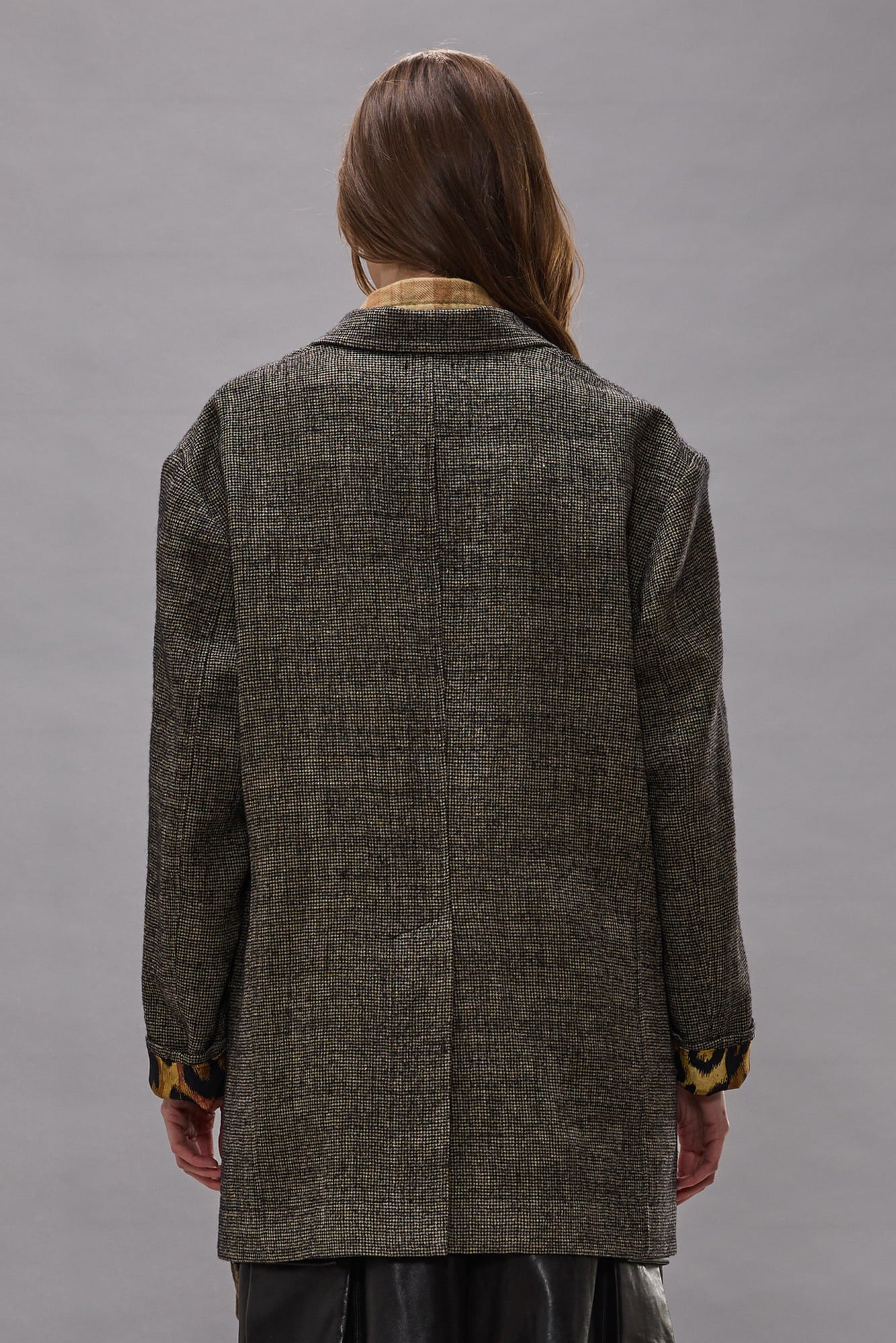 Oversized blazer in khaki and black houndstooth with contrasting patterned sleeve lining, shown from back view.
