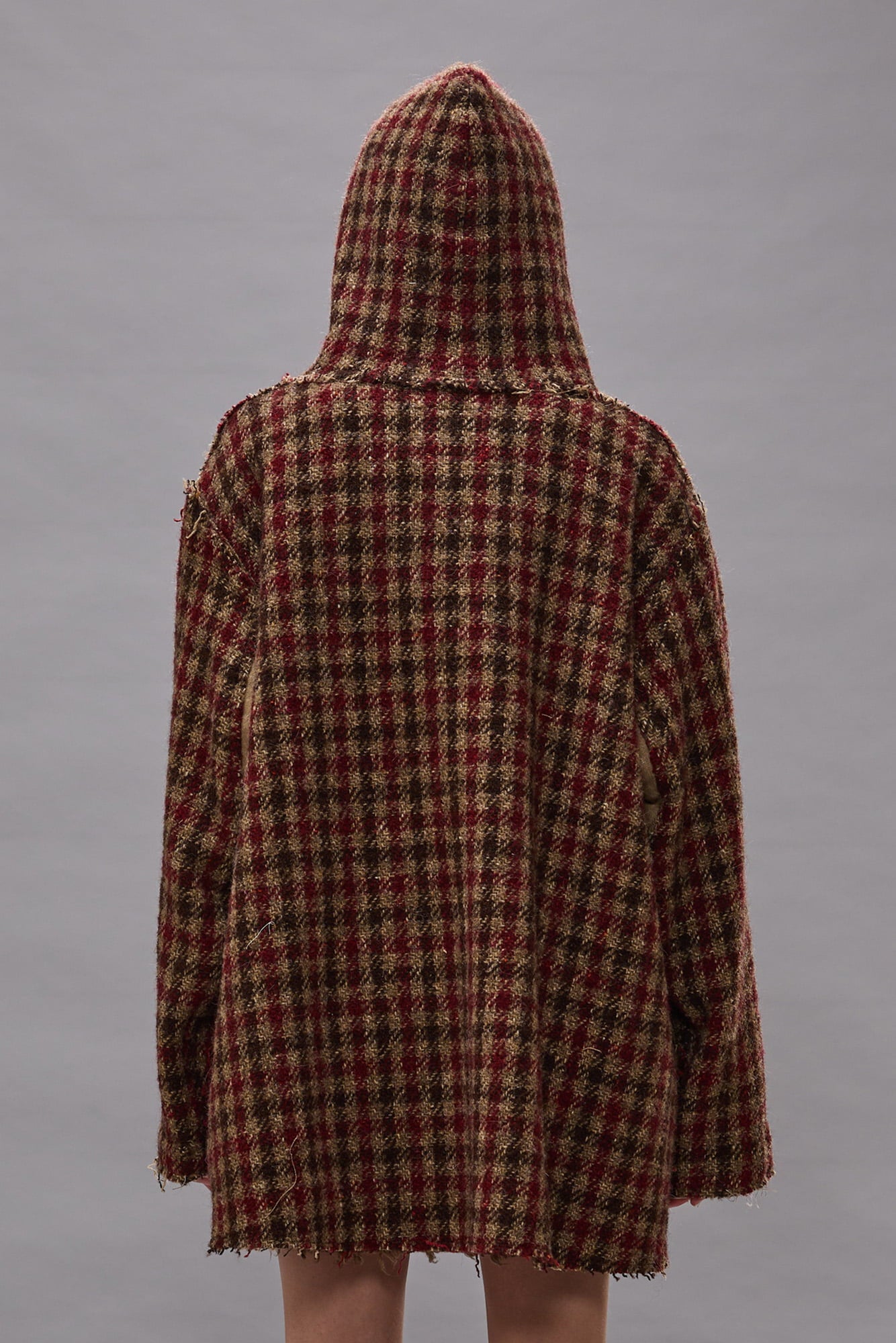 Oversized hooded jacket with red and khaki check pattern, shown from back view on model.