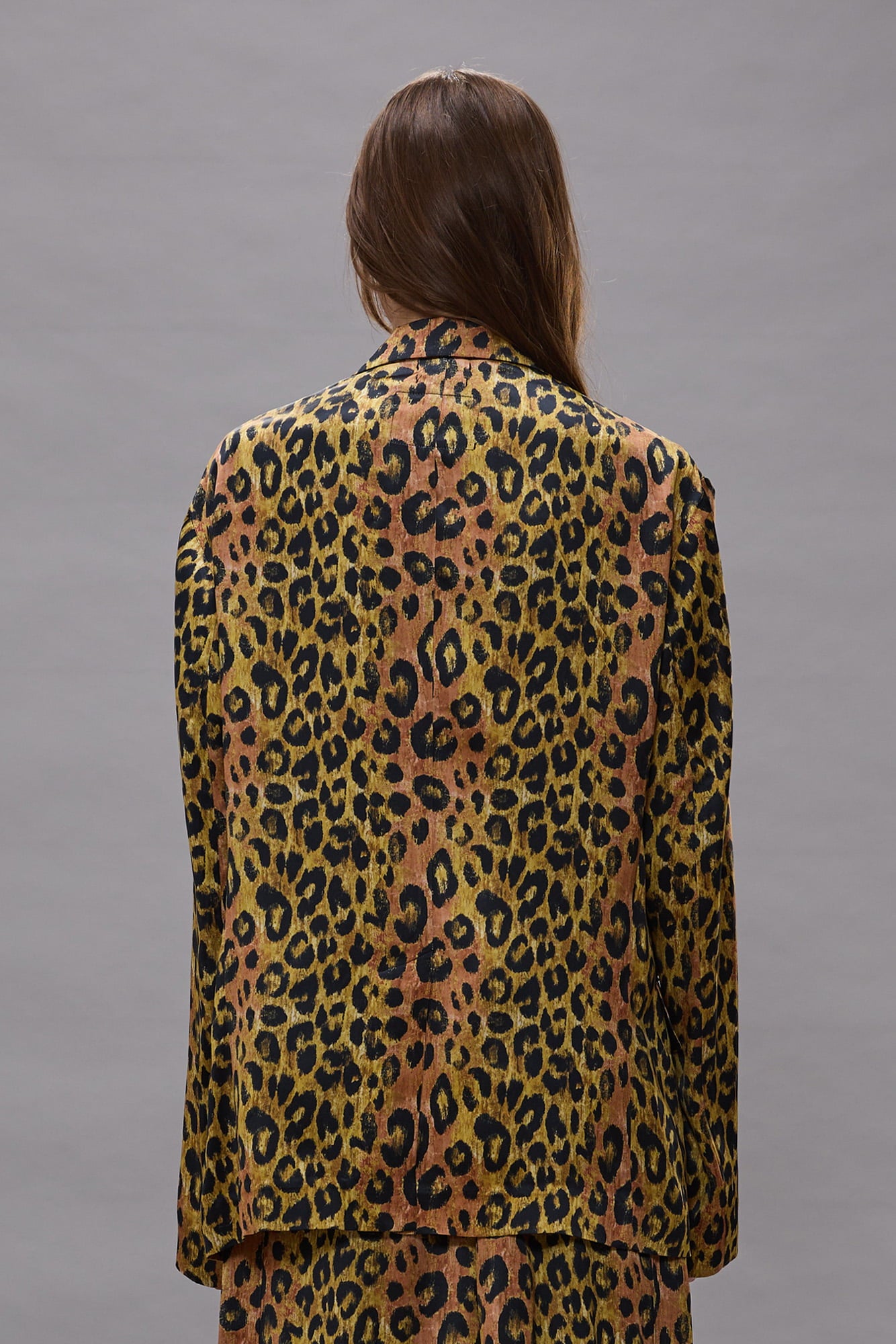 Oversized blazer with leopard print in tan, pink, and black tones, shown from back on model.