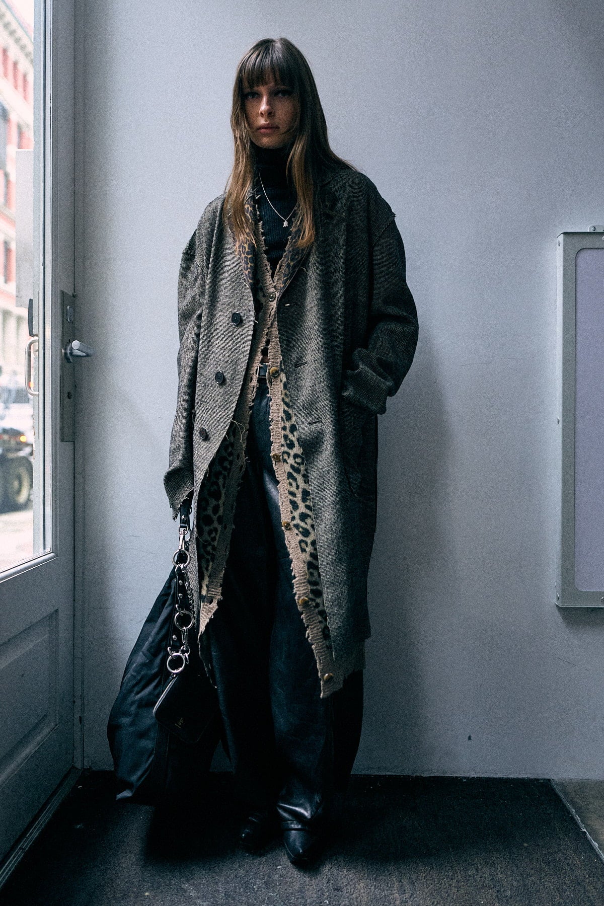 Double layer reversible coat in khaki and black mini houndstooth with raw cut edges and double-breasted buttons.