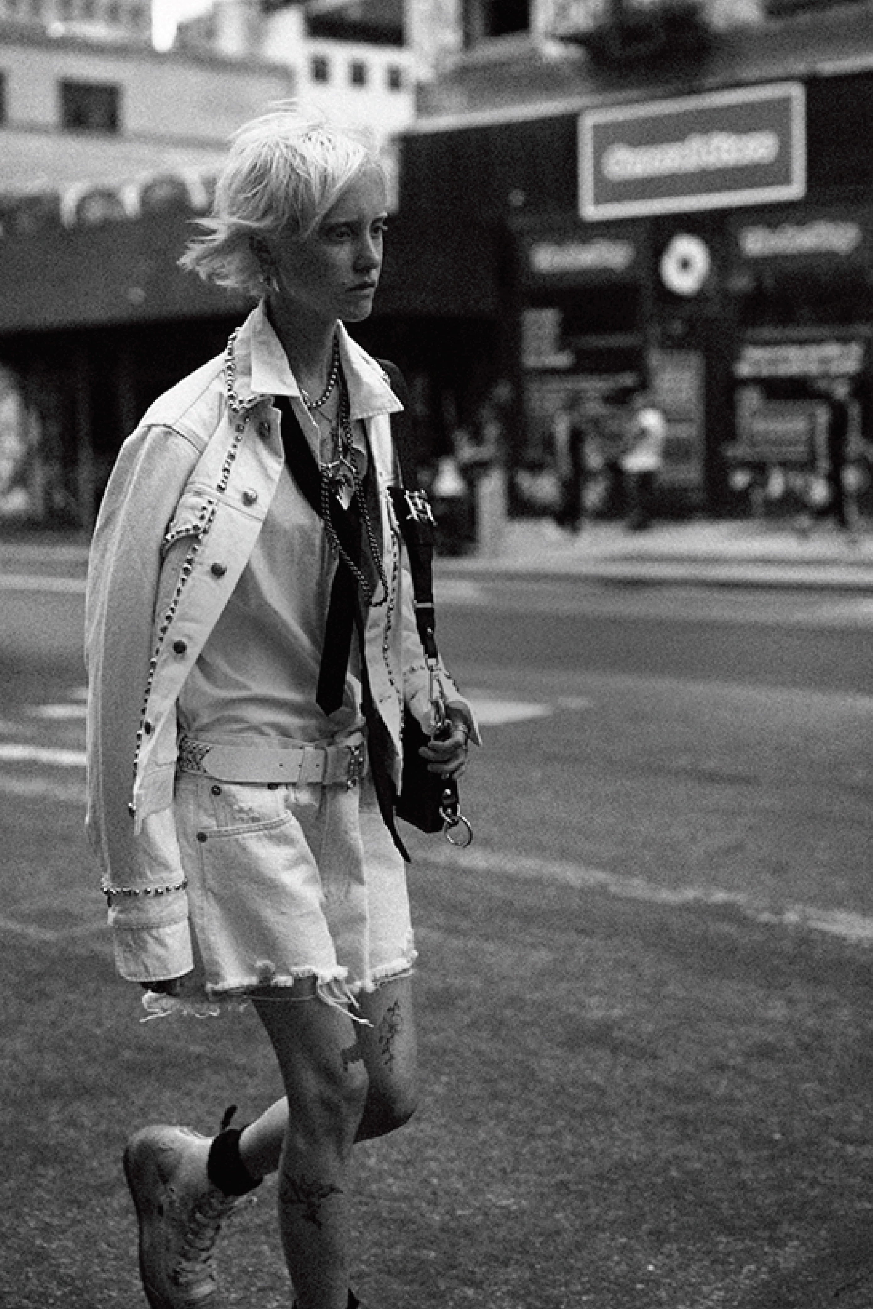 White leather jacket with frayed denim shorts styled with shirt and boots