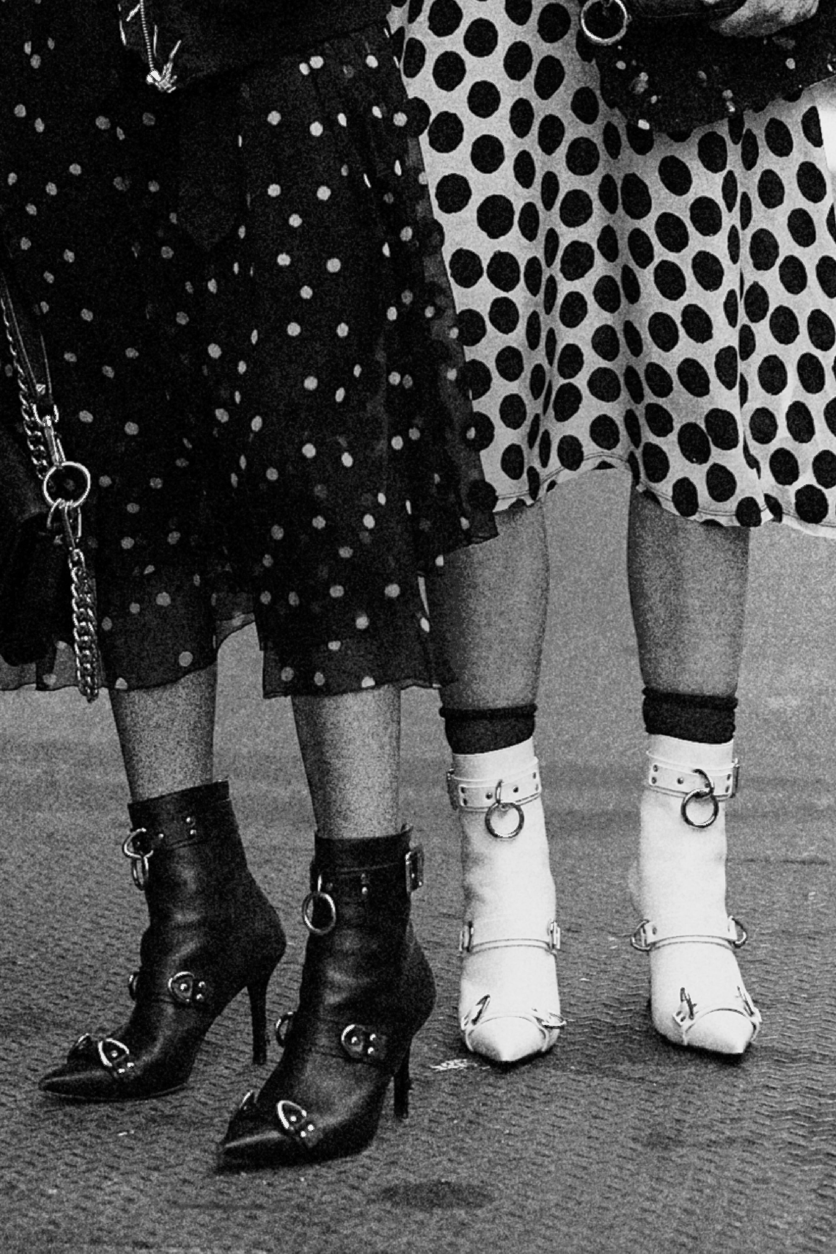 Black and white pointed ankle boots with harness strap accents styled with polka dot skirts