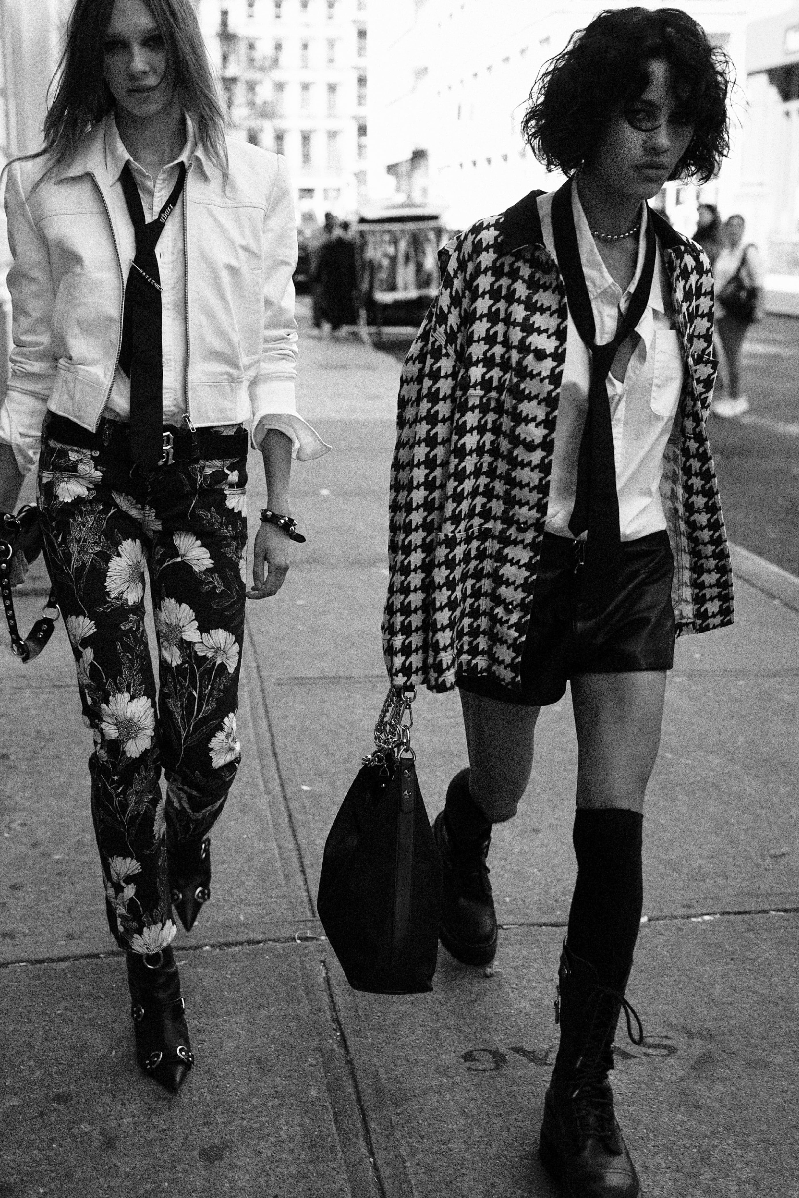 Two models in white shirts and ties with houndstooth jacket and floral trousers